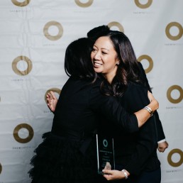 Oakwynite of the year Celine Bacani hugs Morgan Browne at the Oakwyn Sales Kickoff 2020
